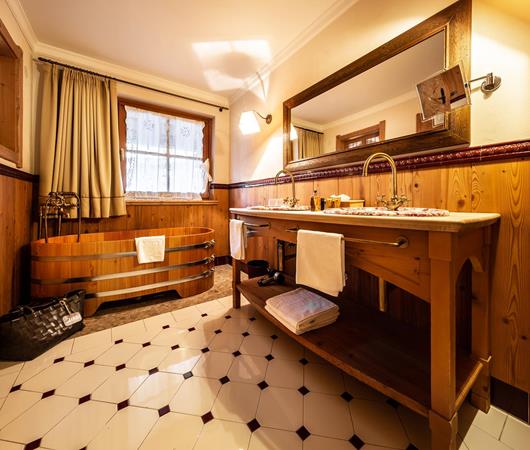 Badezimmer mit Doppelwaschbecken und Badewanne - Doppelzimmer Piz la Ila Superior im Tiroler Stil